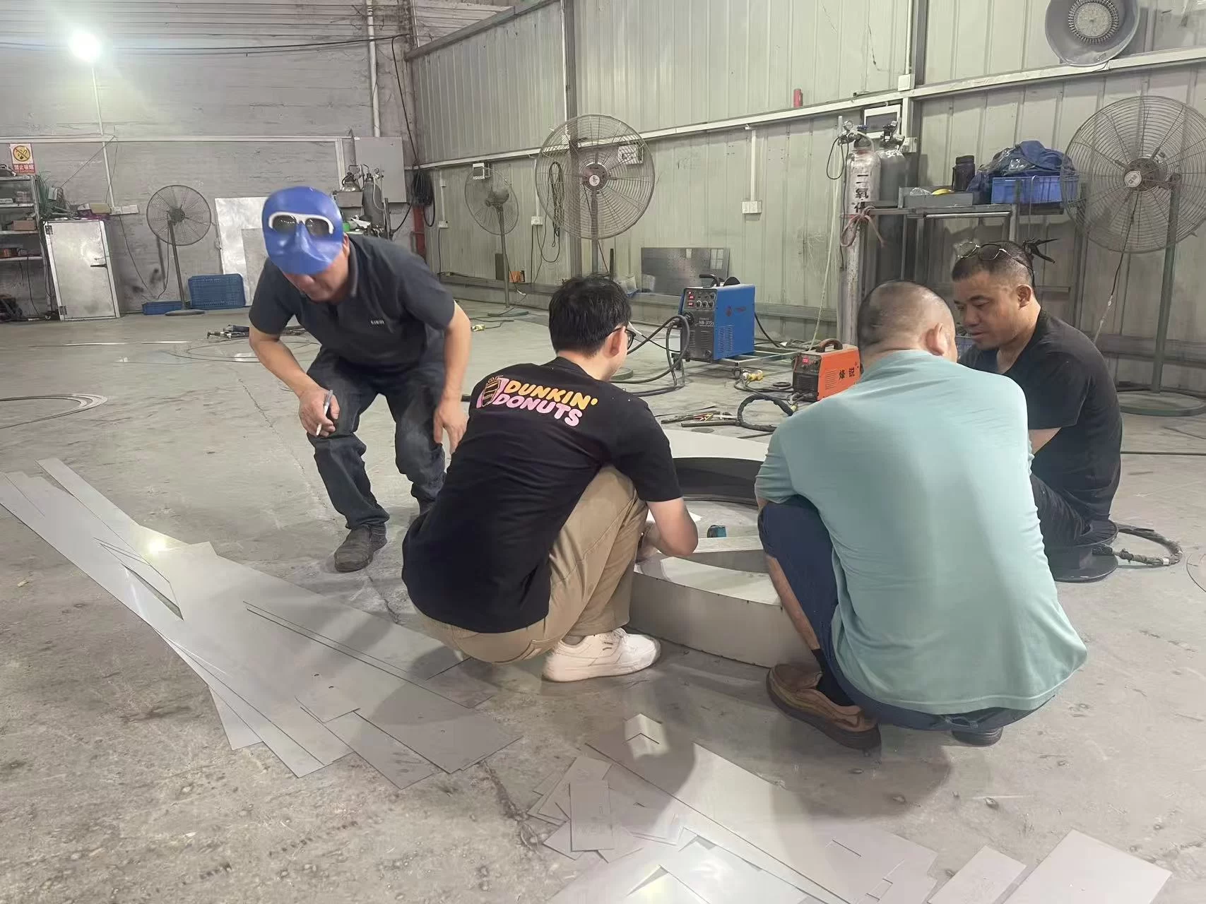 Professional signage design team discussing custom signage solutions at Hongbo Signage factory in China