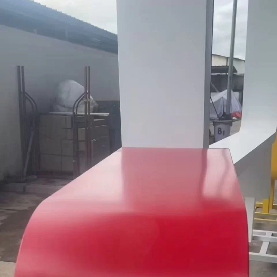 Red powder coated aluminum sign cabinet with rounded corners, custom fascia sign housing in factory workshop