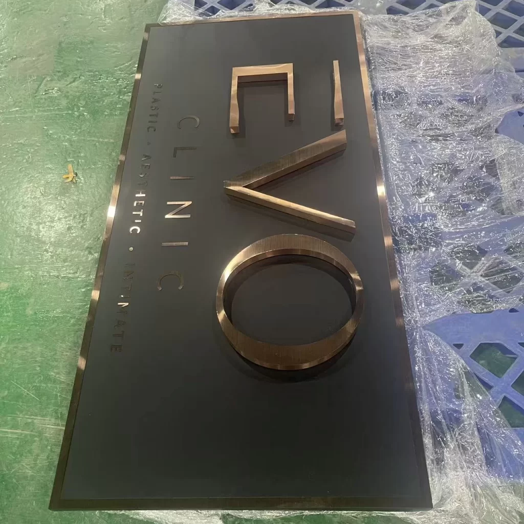 Custom brushed rose gold 3D letters on matte black backboard — non-illuminated metal clinic reception sign, Hongbo Signage factory