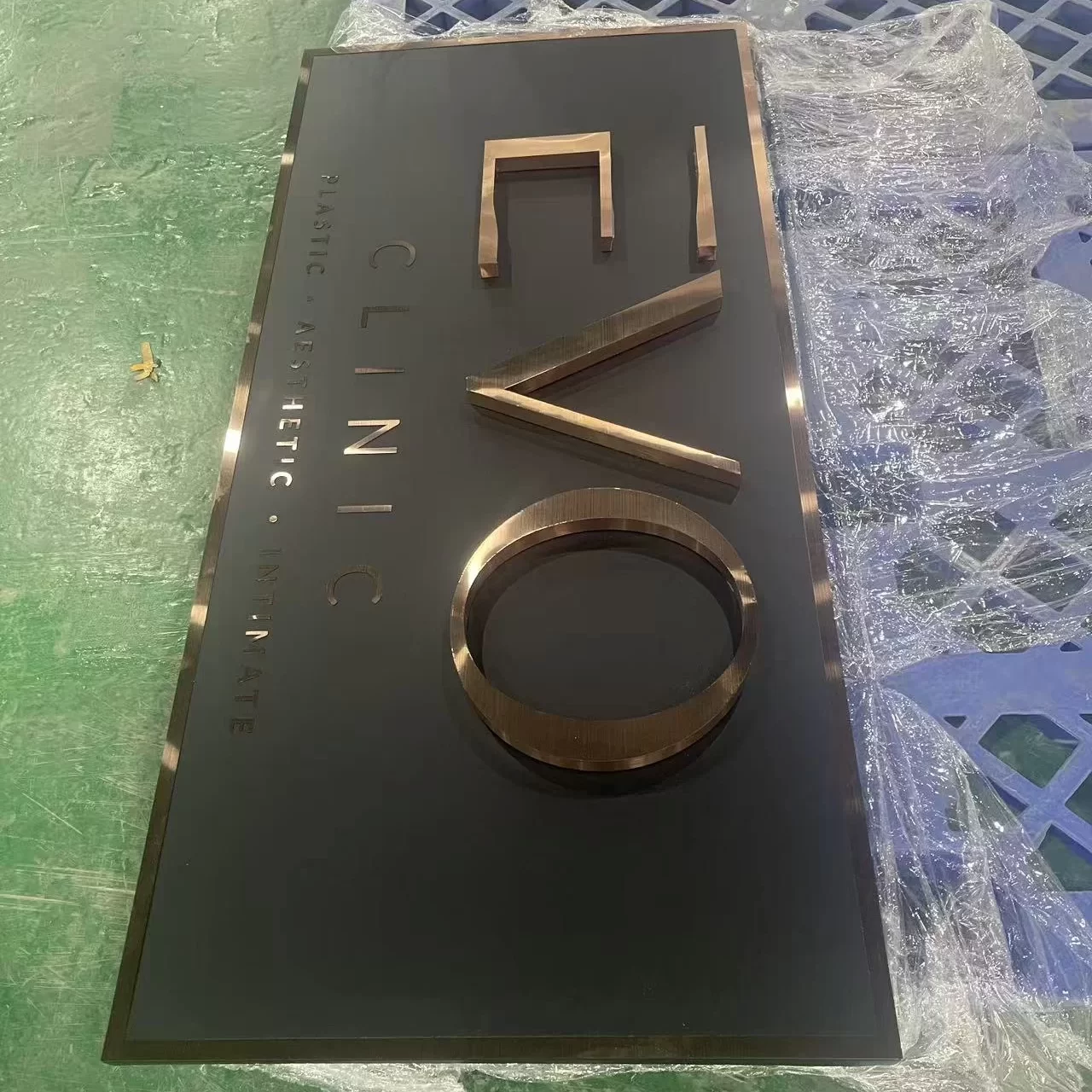 Custom brushed rose gold 3D letters on matte black backboard — non-illuminated metal clinic reception sign, Hongbo Signage factory