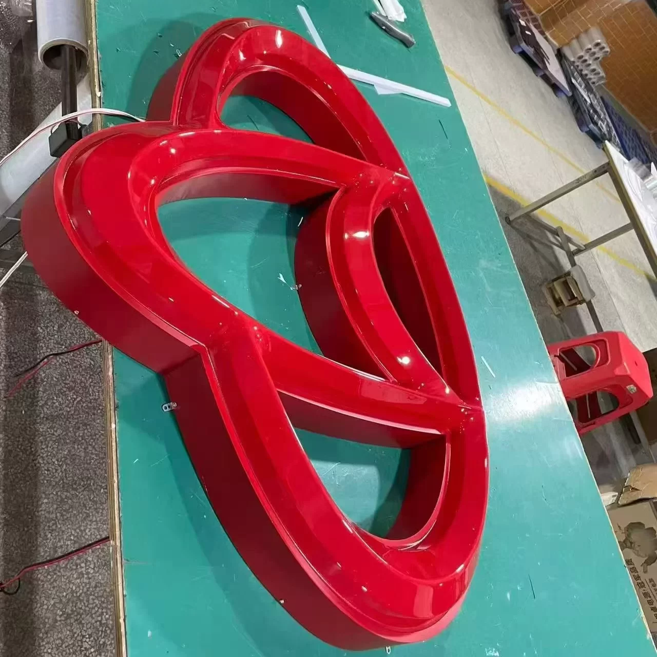 Custom painted channel letters logo — matte red 1K spray-painted metal shell, convex vacuum-formed face, LED front-lit sign in factory
